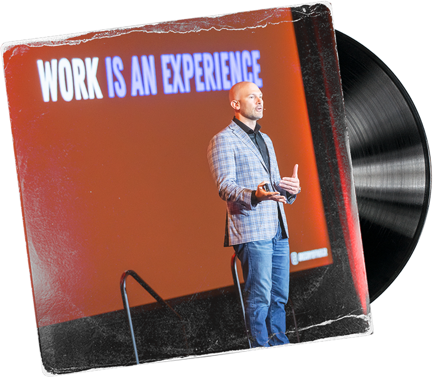 Gregory Offner standing in front of a screen that says Work is an Experience